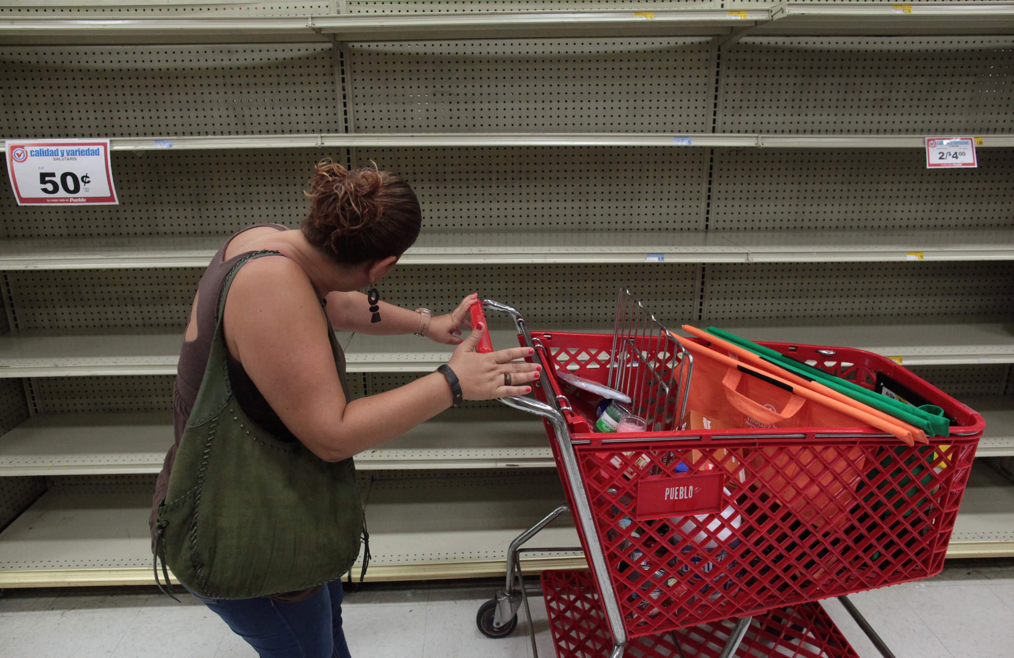 A woman looks at empty shelves that are normally filled with bottles of water after Puerto Rico Governor Ricardo Rossello declared a state of emergency in preparation for Hurricane Irma, in San Juan, Puerto Rico September 4, 2017. (REUTERS/Alvin Baez)