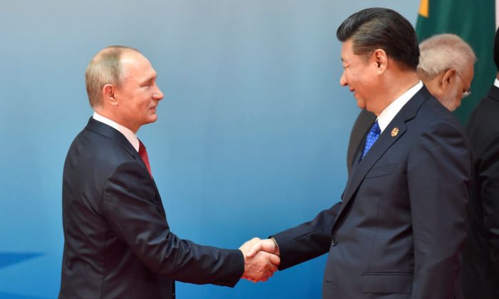 Chinese President Xi Jinping (R) and Russian President Vladimir Putin (L) shake hands before a group photo session at the Dialogue of Emerging Market and Developing Countries on the sidelines of the 2017 BRICS Summit in Xiamen, China, on Sept. 5, 2017.
 (Kenzaburo Fukuhara/AFP/Getty Images)