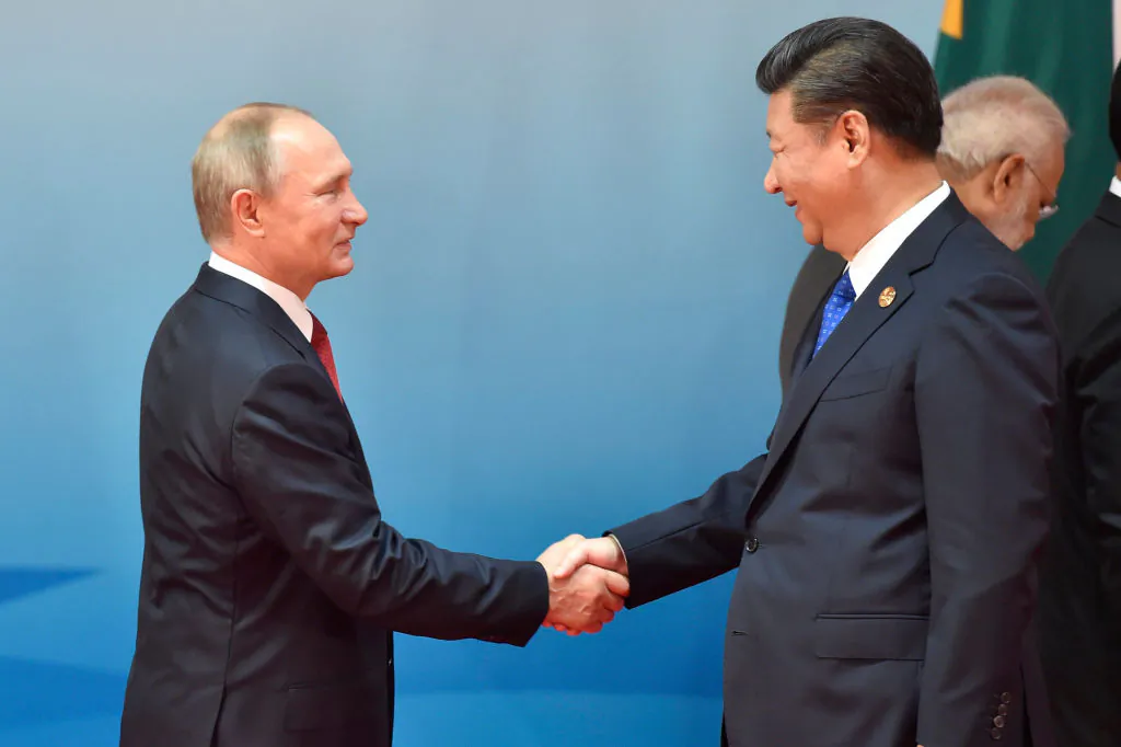 Chinese President Xi Jinping (R) and Russian President Vladimir Putin (L) shake hands before a group photo session at the Dialogue of Emerging Market and Developing Countries on the sidelines of the 2017 BRICS Summit in Xiamen, China, on Sept. 5, 2017.
 (Kenzaburo Fukuhara/AFP/Getty Images)