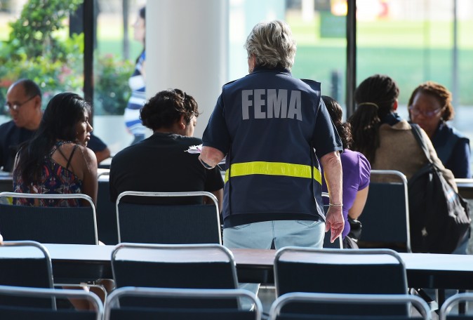 Federal Emergency Management Agency (FEMA) officials help people with questions at the George R. Brown Convention Center which has been a shelter for evacuees from Hurricane Harvey, in Houston on September 2, 2017. One week after Harvey blasted into southeast Texas as a Category Four hurricane, rescuers were still searching by air and by boat for people trapped in flooded homes. / AFP PHOTO / MANDEL NGAN        (Photo credit should read MANDEL NGAN/AFP/Getty Images)