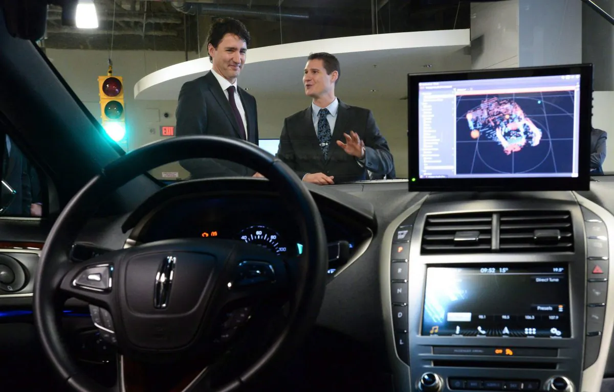 Blackberry QNX director of engineering Sheridan Ethier speaks to Prime Minister Justin Trudeau as he visits the Blackberry QNX facility in Ottawa last year. (The Canadian Press/Sean Kilpatrick)