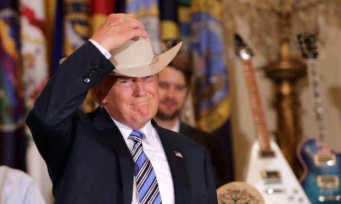 President Donald Trump puts on a Stetson cowboy hat while touring a Made in America product showcase in the East Room of the White House on July 17, 2017. (Chip Somodevilla/Getty Images)