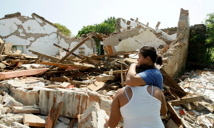 Women hug while standing next to a destroyed house after an earthquake struck the southern coast of Mexico in Union Hidalgo, Mexico on Sept. 9, 2017. (REUTERS/Jorge Luis Plata)