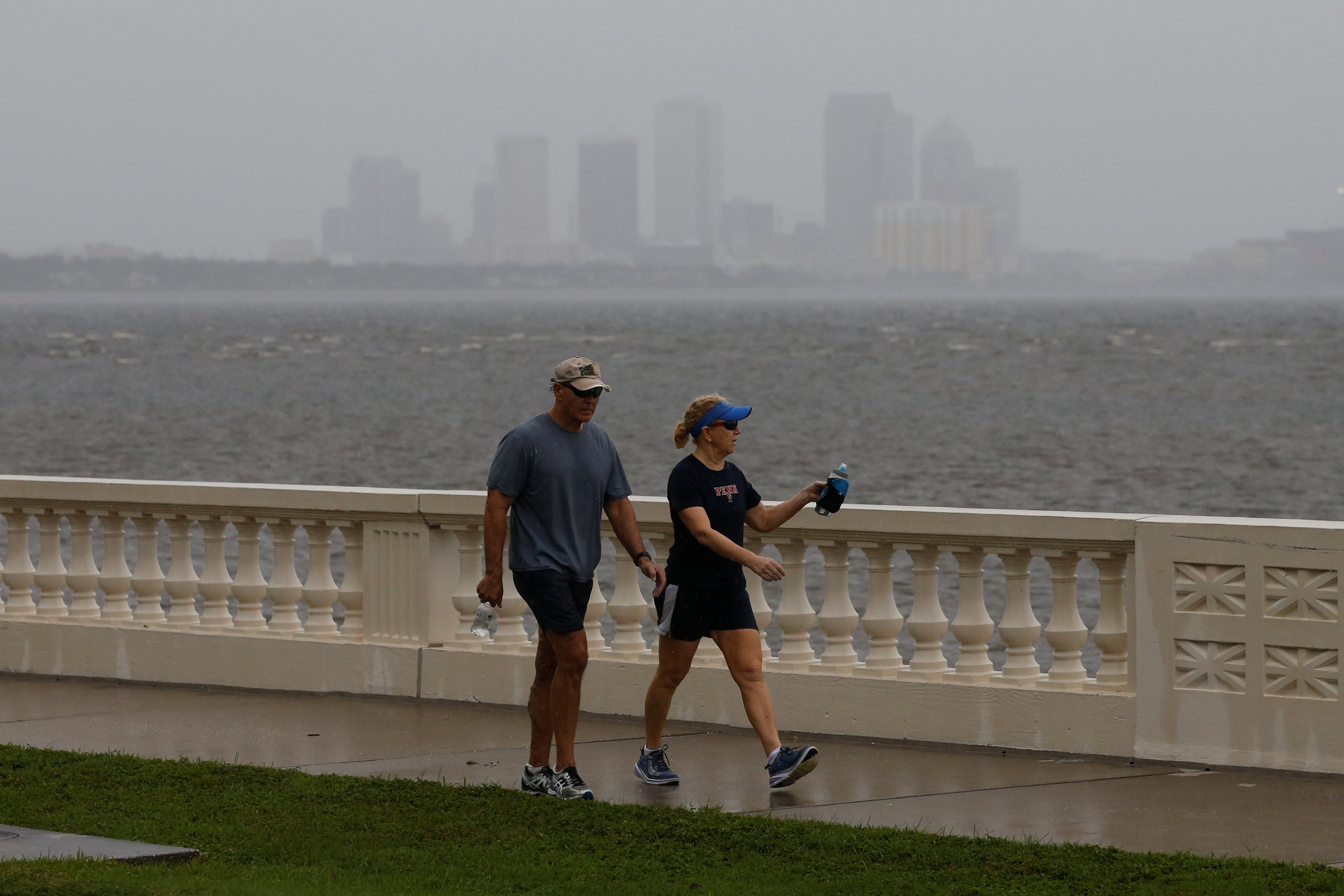 The Tampa skyline is seen in the background as people walk along Bayshore Boulevard ahead of the arrival of Hurricane Irma in Tampa, Florida on Sept. 10, 2017. (REUTERS/Chris Wattie)