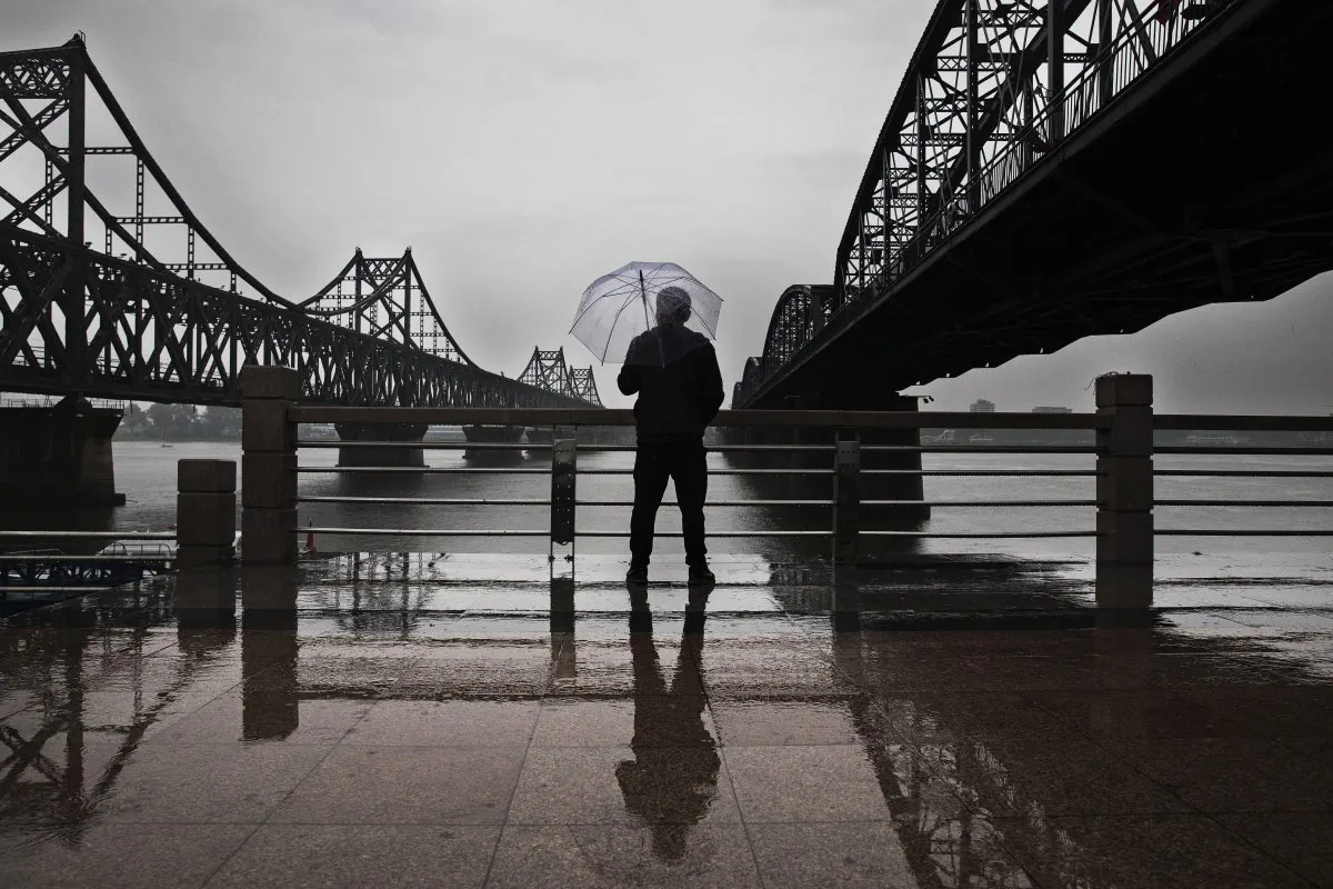 A man looks across the Yalu river in the North Korean city of Sinuiju between the Friendship Bridge (L) and the Broken Bridge that connects the two countries from Dandong, China, on May 23, 2017. (Kevin Frayer/Getty Images)