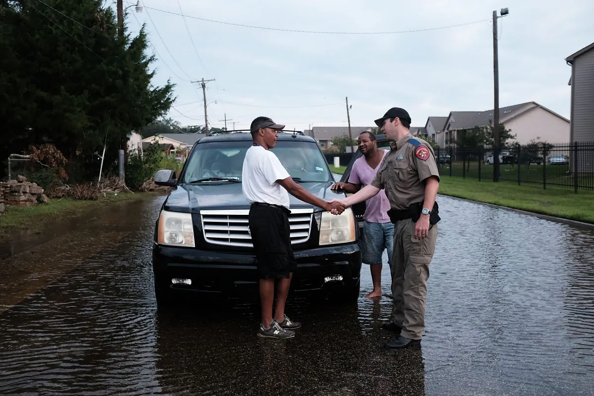 Residents speak with a police officer along a flooded street in Orange as Texas slowly moves toward recovery from the devastation of Hurricane Harvey in Orange, Texas, on Sept. 6, 2017. (Spencer Platt/Getty Images)
