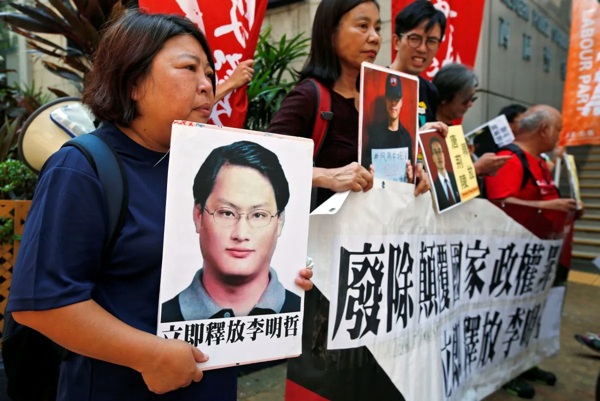 Pro-democracy protesters carry a photo of detained Taiwanese rights activist Lee Ming-Che (L) and other activists during a demonstration in Hong Kong, China on Sept. 11, 2017. (REUTERS/Bobby Yip)