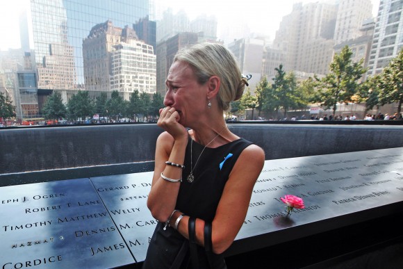 NEW YORK, NY - SEPTEMBER 11: Carrie Bergonia of Pennsylvania looks over the name of her fiance, firefighter Joseph Ogren at the 9/11 Memorial during ceremonies for the twelfth anniversary of the terrorist attacks on lower Manhattan at the World Trade Center site on September 11, 2013 in New York City. The nation is commemorating the anniversary of the 2001 attacks which resulted in the deaths of nearly 3,000 people after two hijacked planes crashed into the World Trade Center, one into the Pentagon in Arlington, Virginia and one crash landed in Shanksville, Pennsylvania. Following the attacks in New York, the former location of the Twin Towers has been turned into the National September 11 Memorial & Museum. (Photo by Chris Pedota-Pool/Getty Images)