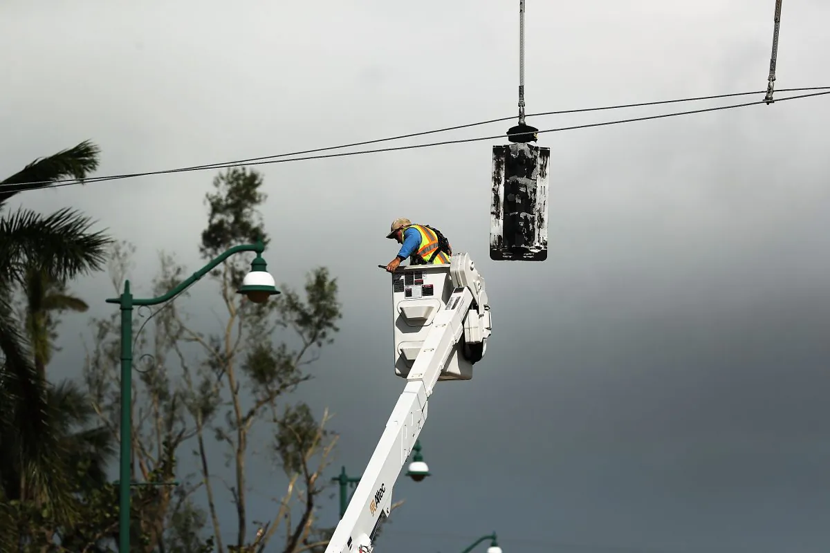 An electrical worker repairs stop lights the morning after Hurricane Irma swept through Naples, Florida on September 11, 2017 (Spencer Platt/Getty Images)
