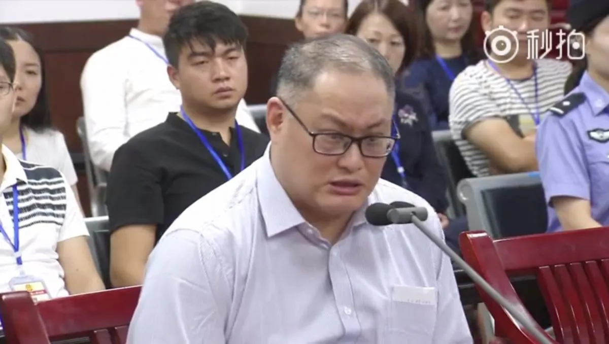 In a video released by the Chinese court, a visibly shaken Lee Ming-che can be seen reading out a statement in court that admits his guilt for “subverting” the Chinse government. Lee’s wife can be seen sitting in the last row of the court room. (Weibo Screenshot/Yueyang Intermediate People's Court)