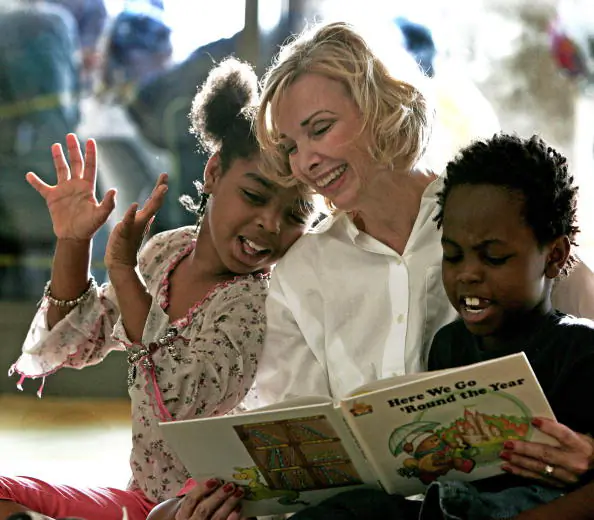 Kindergarden school teacher Janet Thorne who teaches at Northwestern Elementary in nearby Zachary, Louisiana, reads with Hurricane Katrina victims Derrineisha (L), 9, and brother Derrick Early, 8, inside the Riverside Centroplex Red Cross shelter in Baton Rouge, Louisiana on Sept. 3, 2005. (Paul J. Richards/AFP/Getty Images)