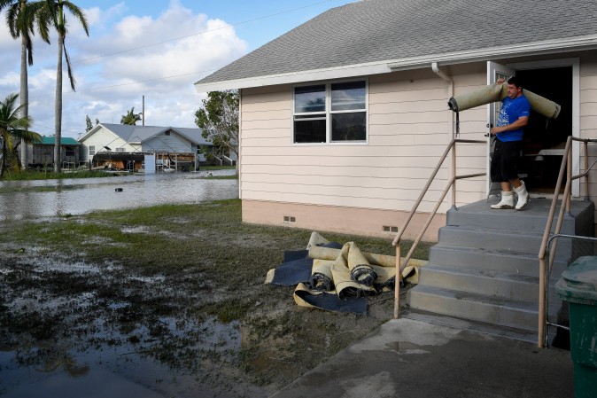 Robert Bonding, 30, removes carpet damaged by Hurricane Irma from The First Baptist Church in Everglades City, Florida, on Sept. 11, 2017. (REUTERS/Bryan Woolston)