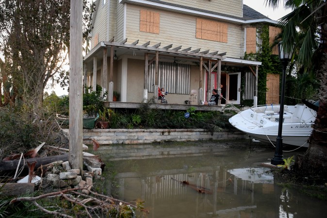 Residents sit on their front porch watching water reside after Hurricane Irma in Everglades City, Florida, on Sept. 11, 2017. (REUTERS/Bryan Woolston)