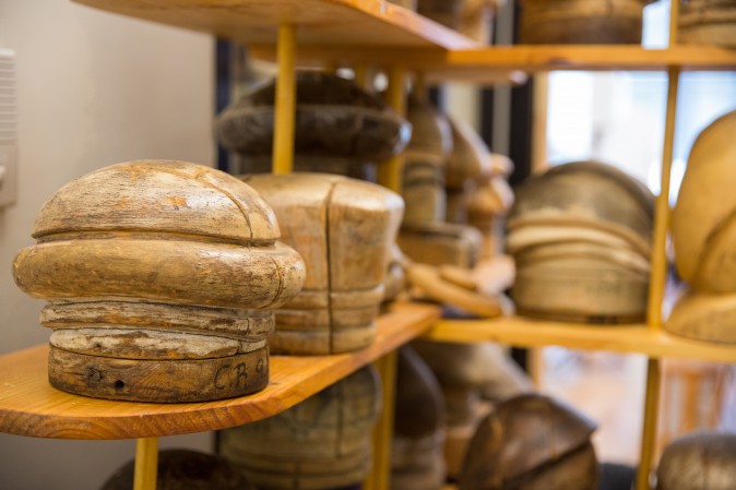 Antique wooden hat blocks which are used to shape the hats are on shelves at the Jennifer Ouellette studio. (Benjamin Chasteen/The Epoch Times)