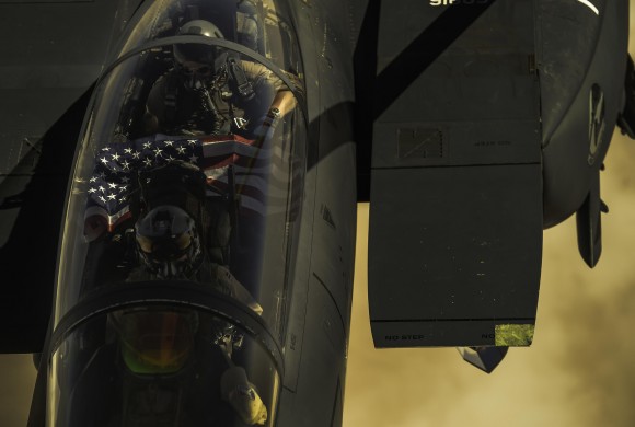 Airmen display an American flag as their F-15E Strike Eagle receives fuel from a KC-135 Stratotanker during a mission over Iraq in support of Operation Inherent Resolve on Sept. 6, 2017. (U.S. Air Force photo by Staff Sgt. Trevor T. McBride)