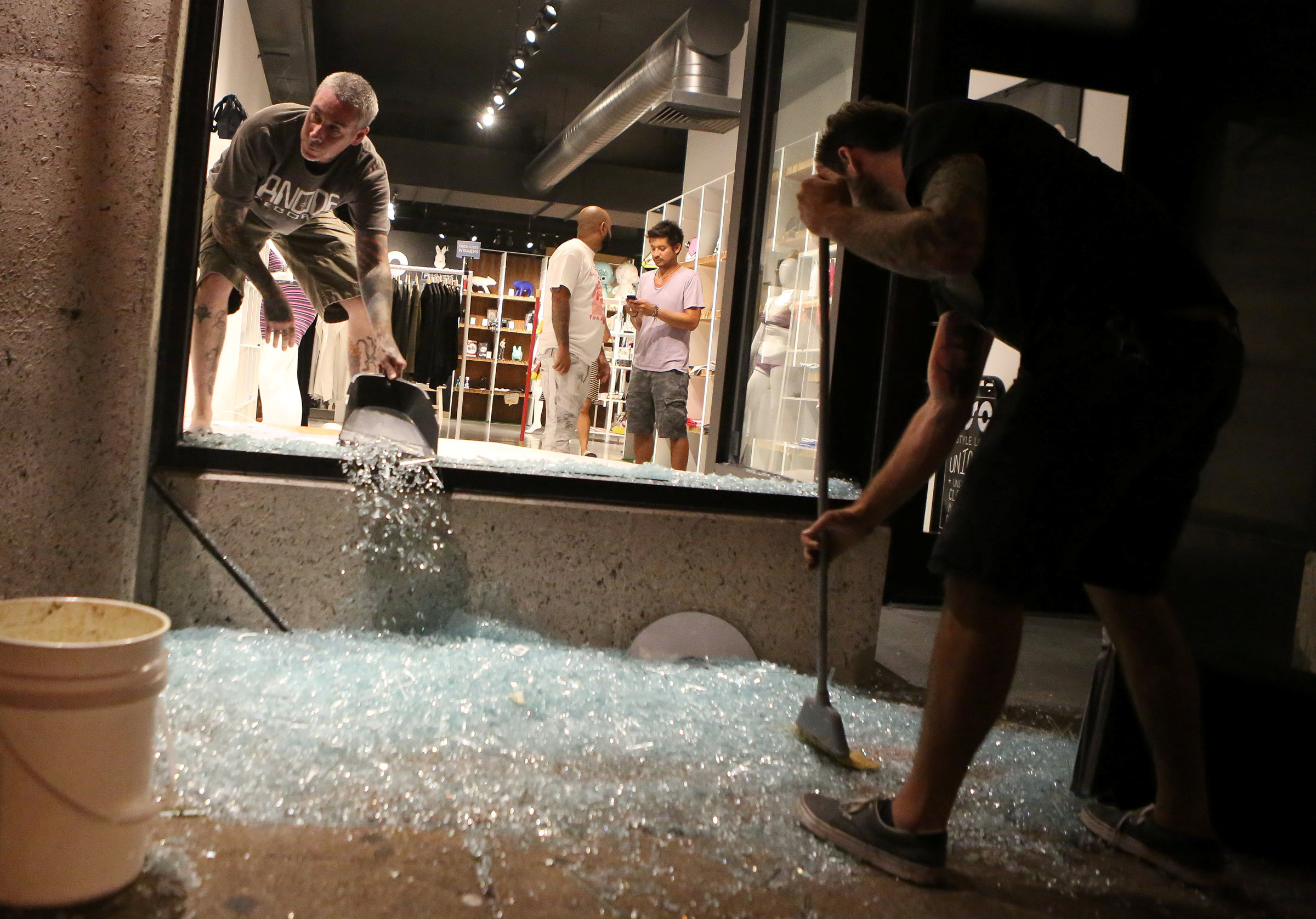 Shopkeepers clean up shattered glass during the second night of demonstrations after a not guilty verdict in the murder trial of former St. Louis police officer Jason Stockley, charged with the 2011 shooting of Anthony Lamar Smith, who was black, in St. Louis, Missouri on Sept. 16, 2017. (REUTERS/Lawrence Bryant)
