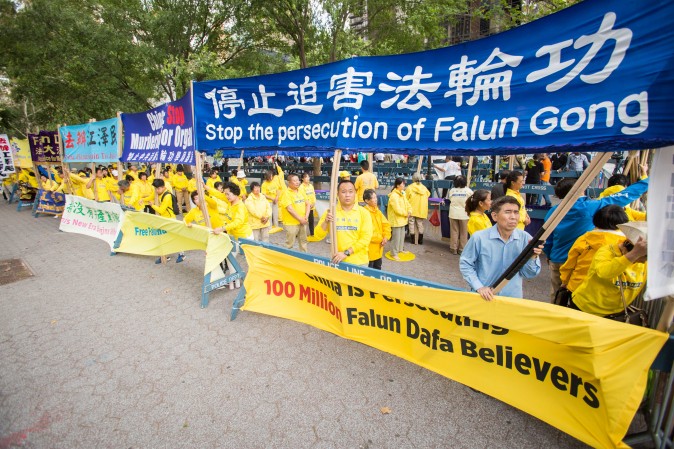 Falun Gong practitioners hold banners and perform exercises to raise awareness about the persecution inside China that is now in its 18th year at the Dag Hammarskjold Plaza near the United Nations headquarters in New York on Sept. 19, 2017. (Benjamin Chasteen/The Epoch Times)