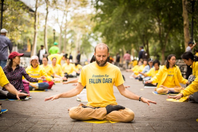 Falun Gong practitioners meditate to raise awareness about the persecution inside China that is now in its 18th year at the Dag Hammarskjold Plaza near the United Nations headquarters in New York while the world leaders meet on Sept. 19, 2017. (Benjamin Chasteen/The Epoch Times)