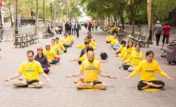 Falun Gong practitioners meditate to raise awareness about the persecution inside China that is now in its 18th year at the Dag Hammarskjold Plaza near the United Nations headquarters in New York while the world leaders meet on Sept. 19, 2017. (Benjamin Chasteen/The Epoch Times)