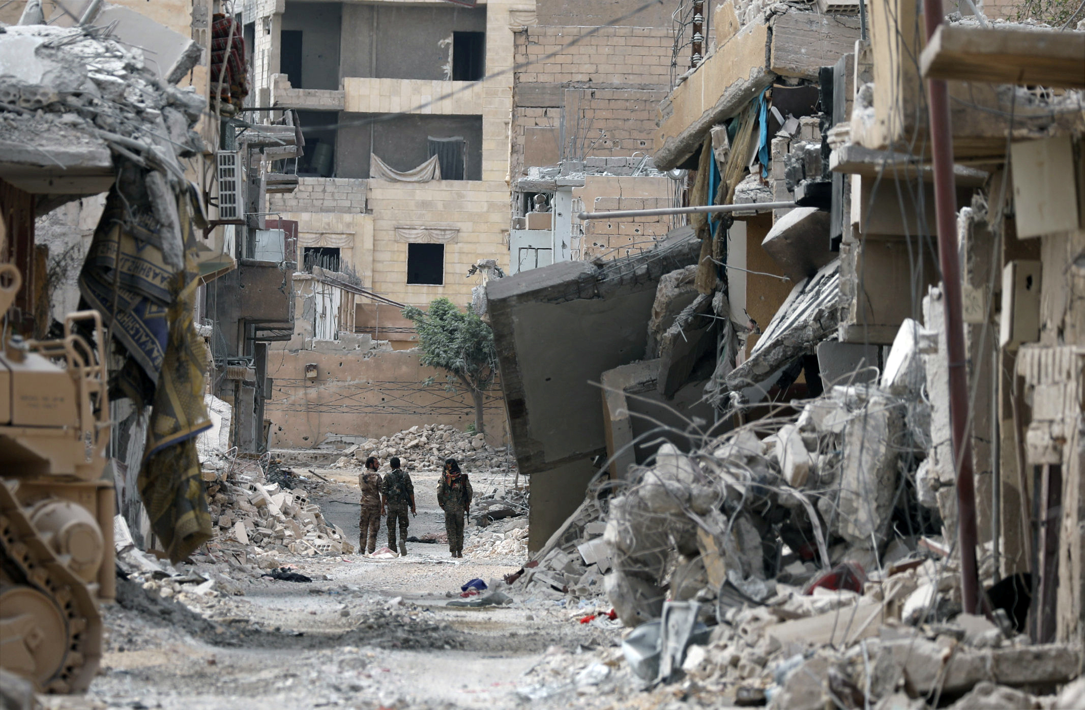 Fighters from Syrian Democratic Forces (SDF) walk together along a damaged street in Raqqa, Syria on Sept. 16, 2017. (REUTERS/ Rodi Said)