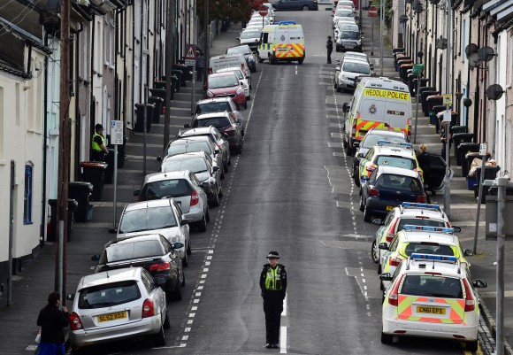 Police officers stand at either end of a street as officers search a house after three men were arrested in connection with an explosion on the London Underground, in Newport, Wales, Britain, September 20, 2017. (Reuters/Rebecca Naden)