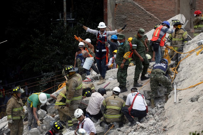 A rescue worker motions for everybody to be quiet in Mexico City. REUTERS/Claudia Daut