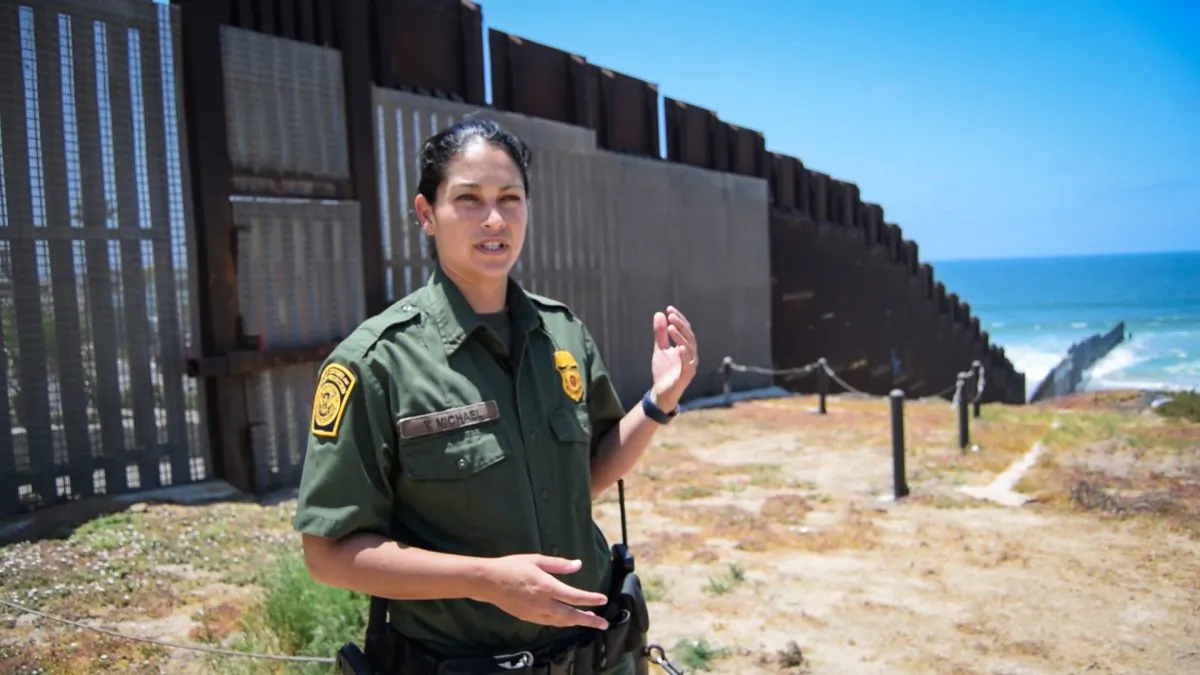 San Diego Border Patrol agent Tekae Michael at the western end of the U.S.–Mexico border barrier in San Diego, Calif., on July 12, 2018. The "PV-1" barrier is designed to stop both pedestrians and vehicles from illegally crossing the border. (Joshua Philipp/The Epoch Times)