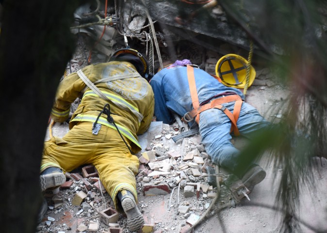A firefighter and a rescuer search for survivors in Mexico City after a strong quake hit central Mexico on Sept. 20, 2017. (ESTRELLA/AFP/Getty Images)