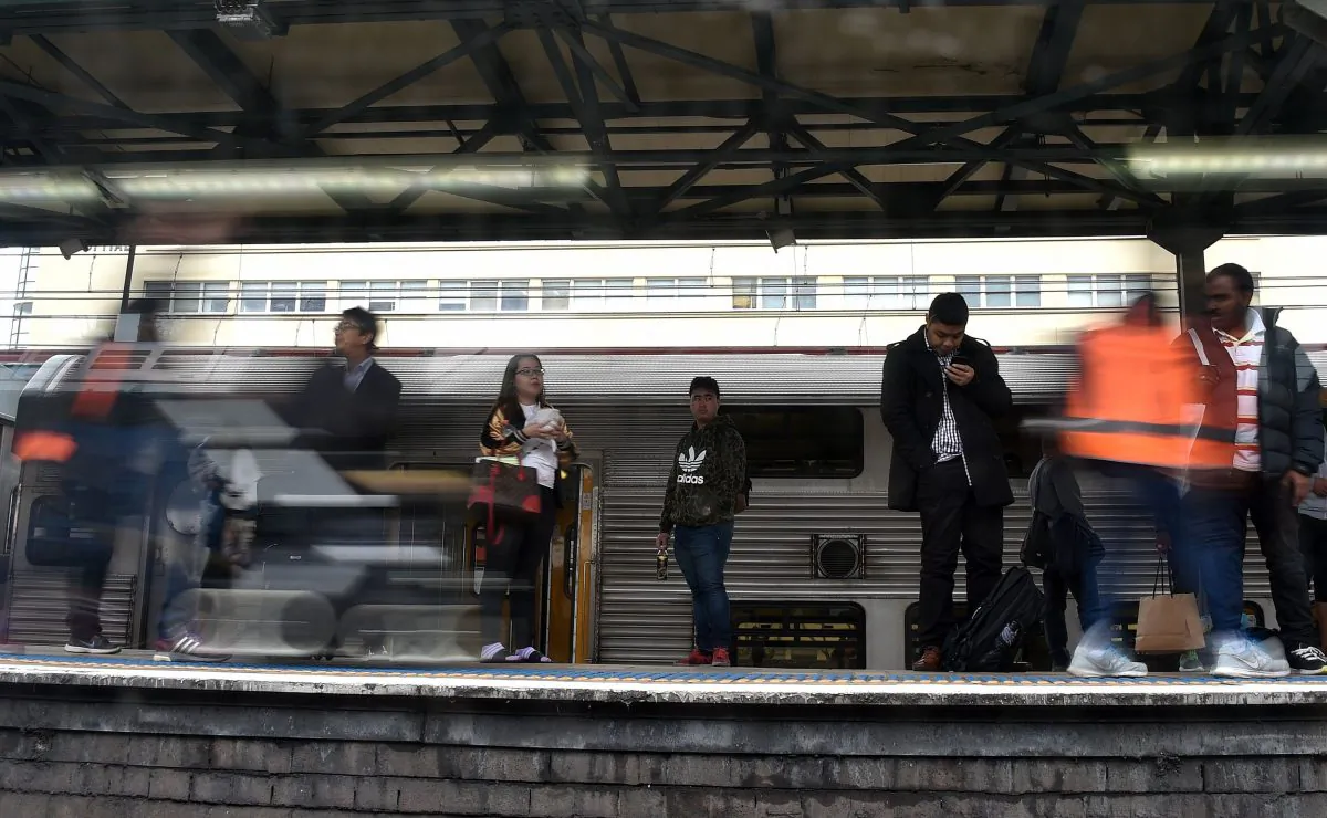 Passengers, seen through a train window, wait on the platform in central business district of Sydney on April 11, 2017. (SAEED KHAN/AFP/Getty Images)