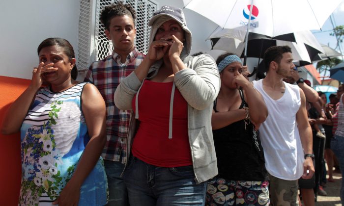 People wait in line for aid items to be handed out in San Juan. (Reuters/Alvin Baez)