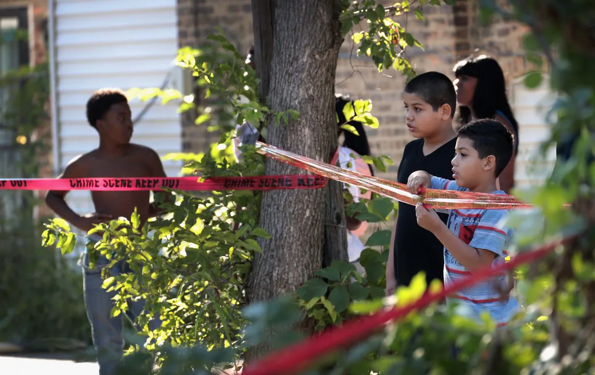 Residents watch as Chicago Police SWAT team members surround a house in the Humboldt Park neighborhood where they believe a man responsible for a nearby murder was hiding on July 27, 2017, in Chicago, Ill. (Scott Olson/Getty Images)