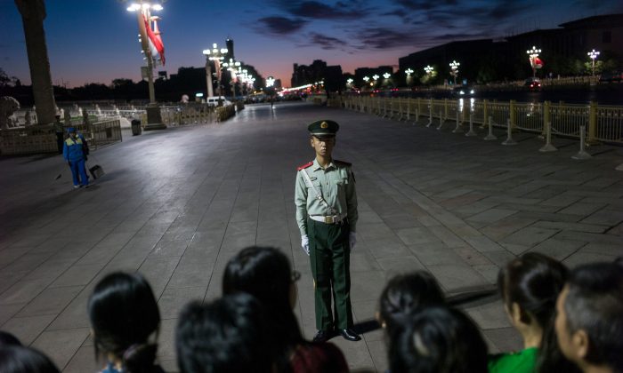 A paramilitary guard stands in front of a crowd at Tiananmen Square in Beijing on Sept. 20, 2017. (Fred Dufour/AFP/Getty Images)