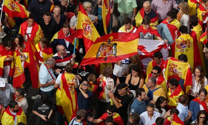A demonstrator waves a pre-constitutional Spanish flag in front of city hall during a demonstration in favor of a unified Spain a day before the banned October 1 independence referendum, in Madrid, Spain, September 30, 2017. (Reuters/Sergio Perez)