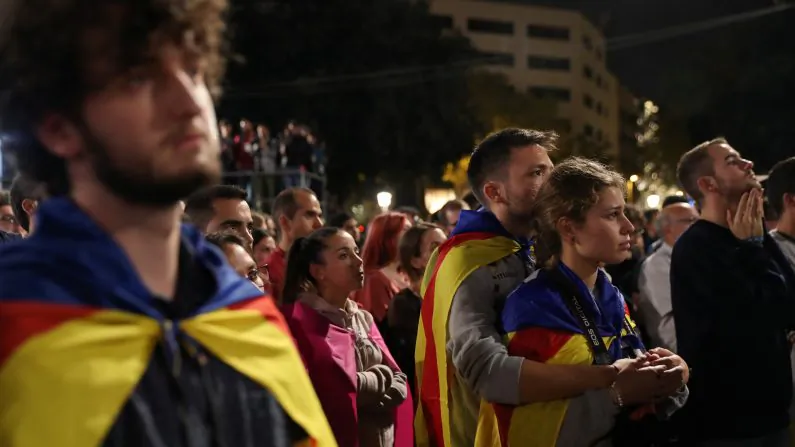 People react as they listen to Catalan president Carles Puigdemont during a gathering at Plaza Catalunya after voting ended for the banned independence referendum, in Barcelona, Spain on Oct. 1, 2017. (REUTERS/Susana Vera)
