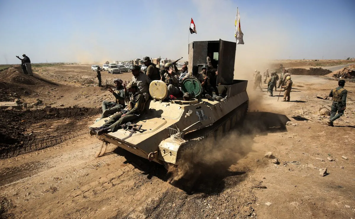 Fighters from the Hashed al-Shaabi (Popular Mobilization) paramilitaries ride atop an infantry-fighting vehicle while advancing towards villages between the northern Iraqi cities of Hawija and Kirkuk after retaking Hawija from ISIS the day before. October 6, 2017. (Ahmad Al-Rubaye/AFP/Getty Images)