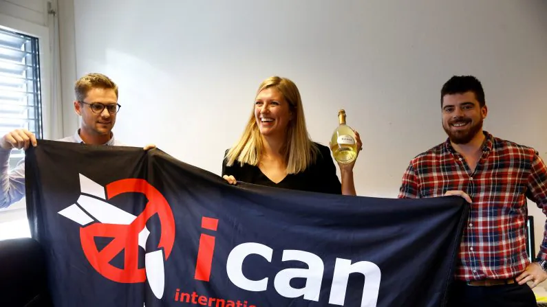 Beatrice Fihn, Executive Director of the International Campaign to Abolish Nuclear Weapons (ICAN) receives a bottle of champagne from her husband Will Fihm Ramsay (R) next to Daniel Hogsta, coordinator, while they celebrate after ICAN won the Nobel Peace Prize 2017, in Geneva, Switzerland on Oct. 6, 2017. (REUTERS/Denis Balibouse)