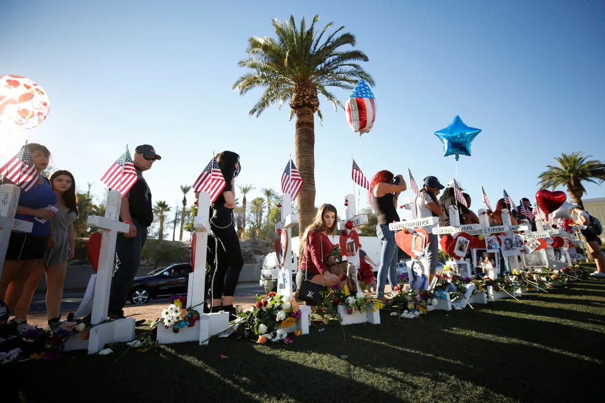 A woman places a flower in front of one of many white crosses set up for the victims of the Route 91 Harvest music festival mass shooting in Las Vegas, Nevada, U.S., October 6, 2017. (Reuters/Chris Wattie)