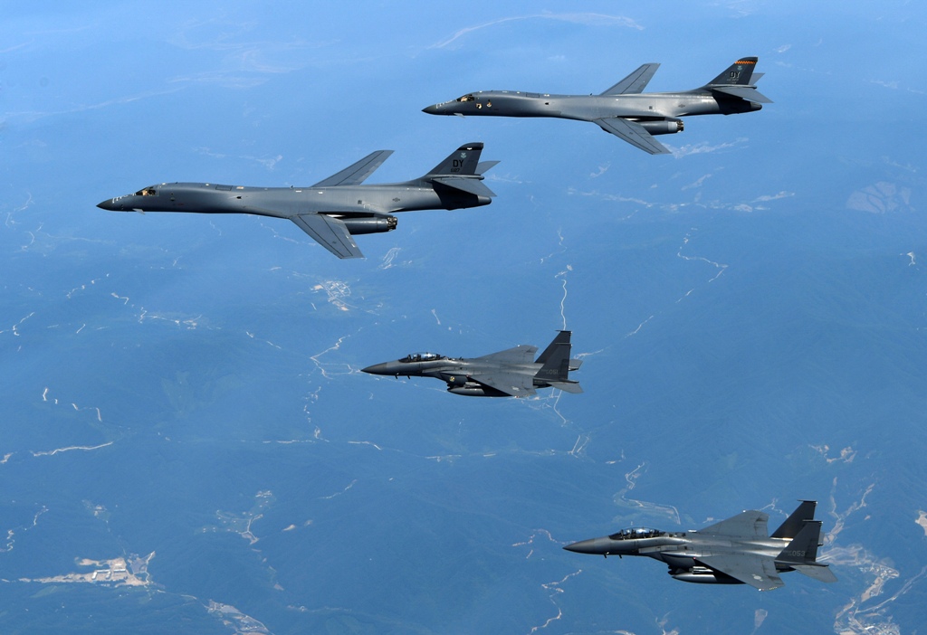 在这张由韩国国防部提供的 2017 年 6 月 20 日的档案照片中，美国空军 B-1B 轰炸机（从上到下）和韩国战斗机 F-15K 飞越韩国朝鲜半岛。  （韩国国防部通过美联社，文件）