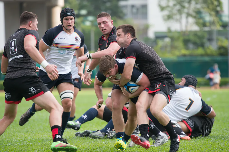 A resolute charge by HKCC scrumhalf Jack Metters is slowed by Valley fullback Doug Fluker and finally brought to a standstill as scrumhalf Ruan DuPlooy lends a hand, in the HKRU Premiership match at Aberdeen Sports Ground on Saturday Oct 7. HKCC capitalised on Metter’s good work by scoring in the next phase. (Bill Cox/Epoch Times)