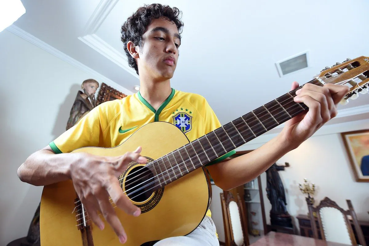 Joao de Assis, who is born with twelve fingers, plays guitar in his home in Brasilia, on June 21, 2014. (AFP PHOTO/ EVARISTA SA)