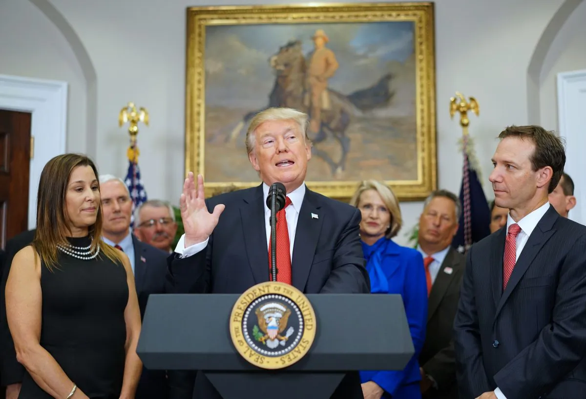 President Donald Trump, flanked by business owners Leslie Baudry (L) and Rich Baudry, speaks before signing an executive order on health insurance on Oct. 12, 2017. (MANDEL NGAN/AFP/Getty Images)