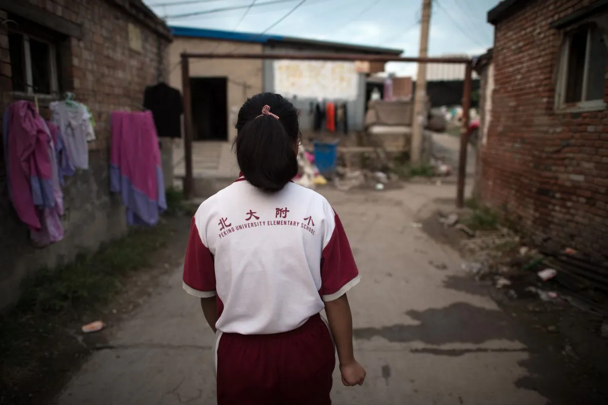 In this picture taken on August 17, 2017, a girl walks toward a goalpost on a street in a migrant village on the outskirts of Beijing.
Surrounded by the sleek hi-tech campuses and luxury condominiums of "Beijing's Silicon Valley", migrants from the countryside recreate village life, cooking in outdoor communal areas, playing cards and showering in the street. But their community's days are numbered. (NICOLAS ASFOURI/AFP/Getty Images)
