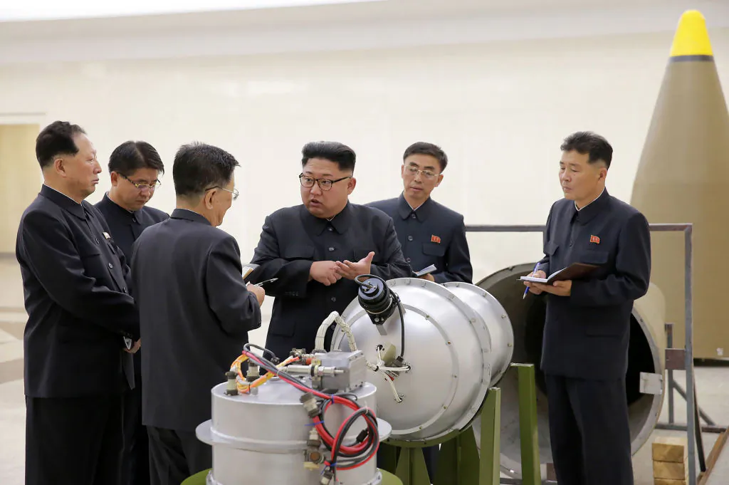 In this undated photo released by North Korea's official Korean Central News Agency (KCNA) on Sept. 3, 2017, North Korean leader Kim Jong Un (C) looking at a metal casing with two bulges at an undisclosed location. (STR/AFP/Getty Images)