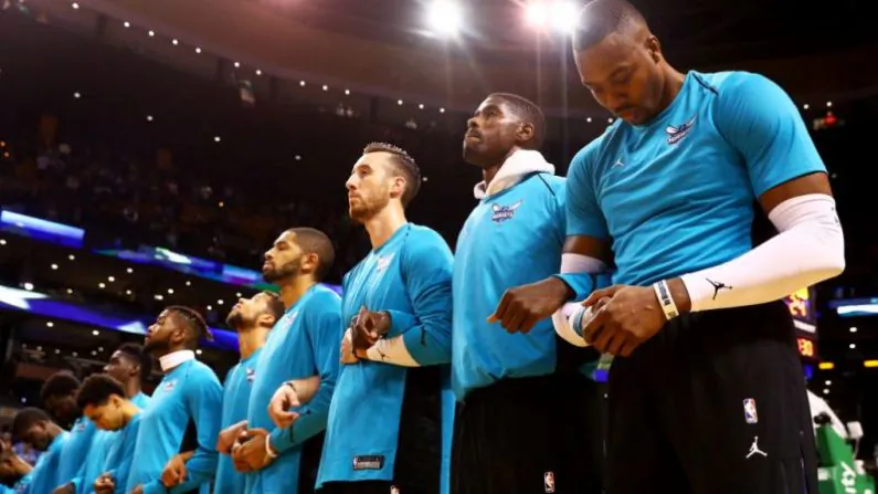 Dwight Howard #12 of the Charlotte Hornets, right, links arms with teammates during the national anthem before the game against the Boston Celtics at TD Garden on October 2, 2017 in Boston, Massachusetts. (Photo by Maddie Meyer/Getty Images)