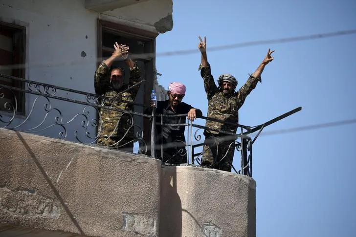 Fighters from the Syrian Democratic Forces give the "V" sign at the frontline in Raqqa, Syria on Oct. 16, 2017.      (REUTERS/Rodi Said)