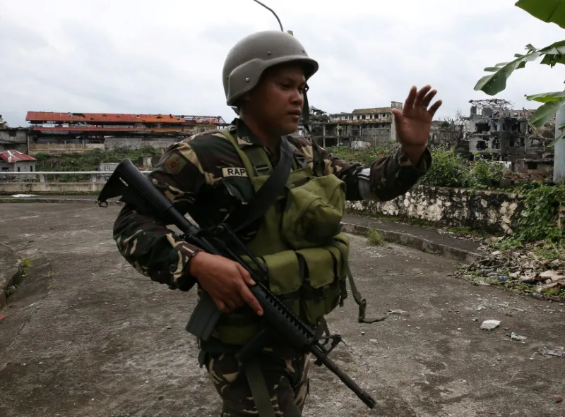 A government soldier gestures during as they clear the area with the local government members inside a war-torn in Marawi city, southern Philippines Oct. 19, 2017. (Reuters/Romeo Ranoco)