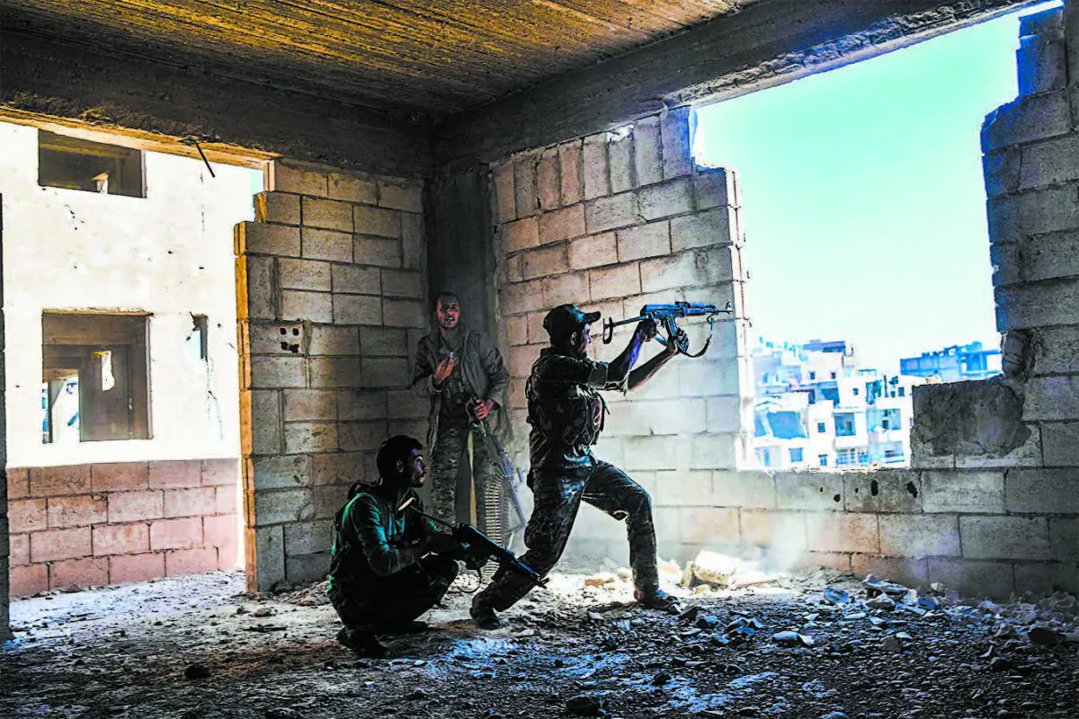 Members of the Syrian Democratic Forces fire their arms during a battle against ISIS terrorists to retake the central hospital of Raqqa, Syria, on the western frontline of the city on Sept. 28. (BULENT KILIC/AFP/GETTY IMAGES)