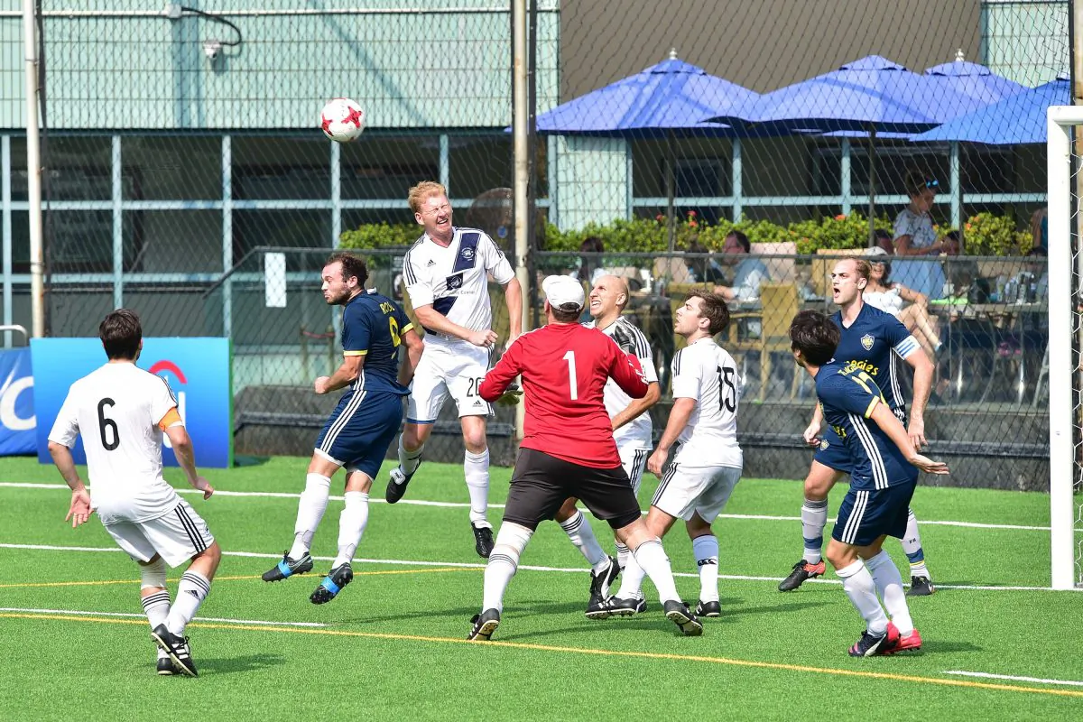 Albion's Tom Pugh heads clear during Albion's 3-1 Yau Yee League Div 1 victory over Carnegies Boca Seniors watched by goalkeeper James Seddon and defender Colin Spanos. (Bill Cox/Epoch Times)