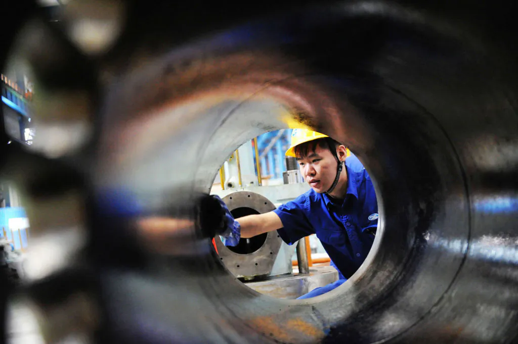 A worker cleaning a diesel engine part in Qingdao, China, Aug. 29, 2017. China's economy has been strong recently but Daniel Lacalle argues there will be a price to pay. 
(STR/AFP/Getty Images)