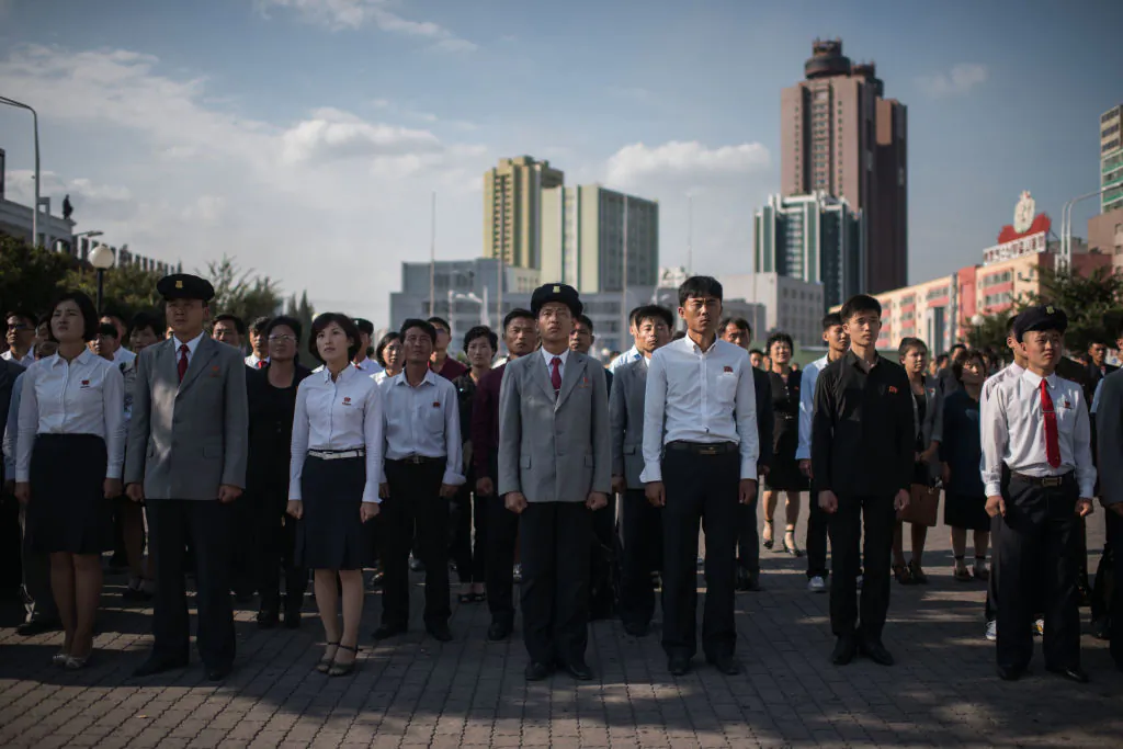 Spectators listen to a television news brodcast of a statement by North Korean leader Kim Jong-Un, before a public television screen outside the central railway station in Pyongyang on September 22, 2017.(ED JONES/AFP/Getty Images)